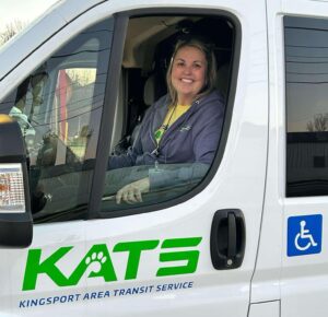 a woman sitting in the driver's seat of a white van